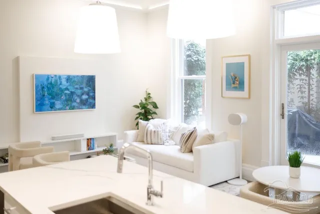 a room with a table chairs and a kitchen view