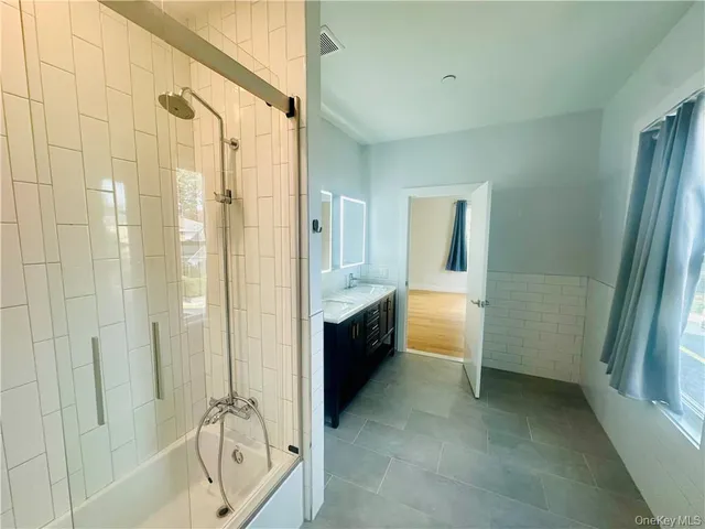 a bathroom with a double vanity sink a toilet and shower