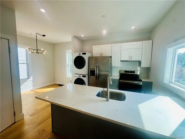 a kitchen with a sink a refrigerator and a stove top oven