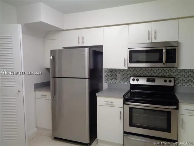 a kitchen with cabinets and stainless steel appliances