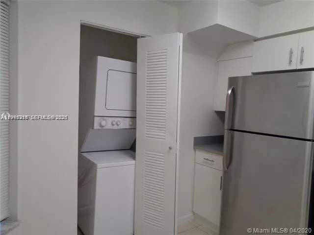 a white refrigerator freezer and a stove sitting inside of a kitchen