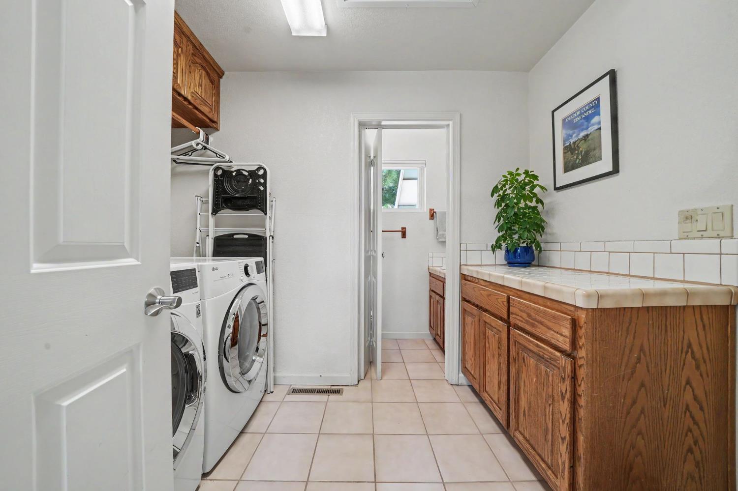 18299 West Clinton Road Jackson, CA 95642 - Photo 29 of 56 a utility room with cabinets washer and dryer