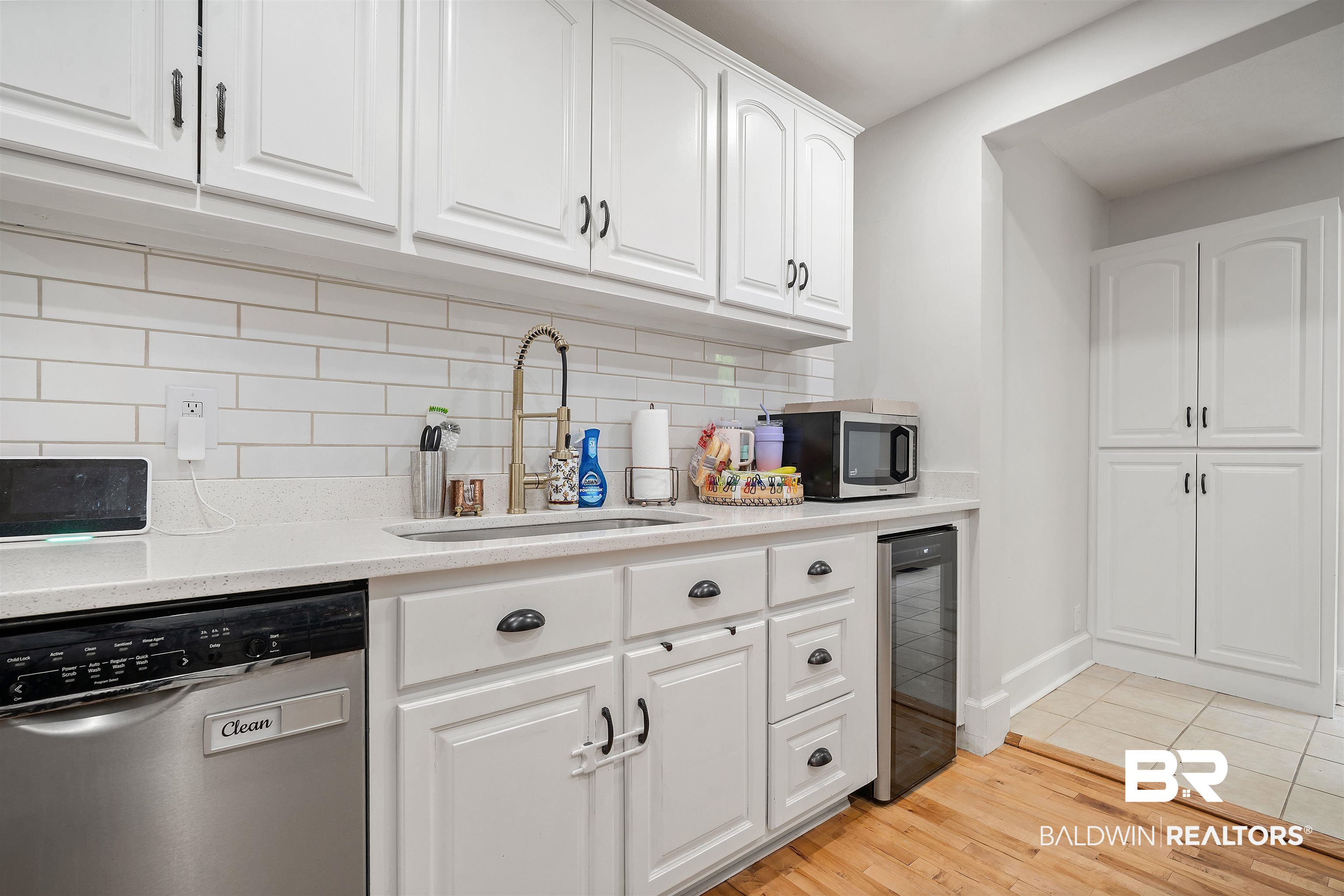 103 Emogene Place Mobile, AL 36606 - Photo 11 of 32 Kitchen featuring white cabinetry, stainless steel appliances, light wood-style floors, wine cooler, and light stone countertops