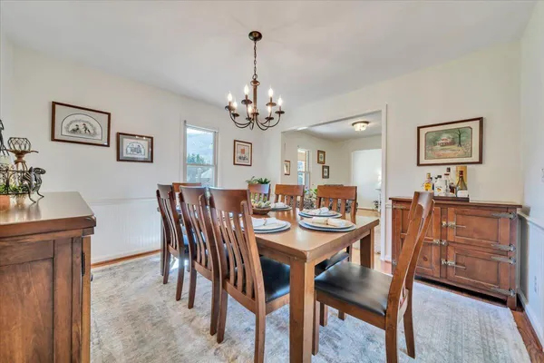 a view of a dining room with furniture a chandelier and wooden floor