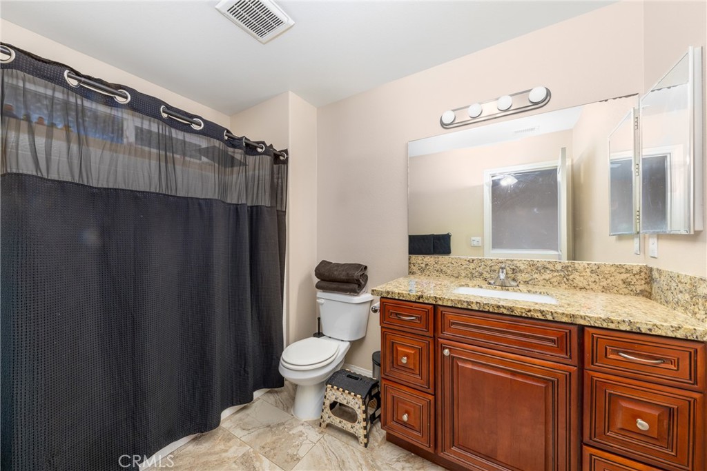 14632 Maricopa Road Victorville, CA 92392 - Photo 13 of 43 a bathroom with a granite countertop sink toilet and shower