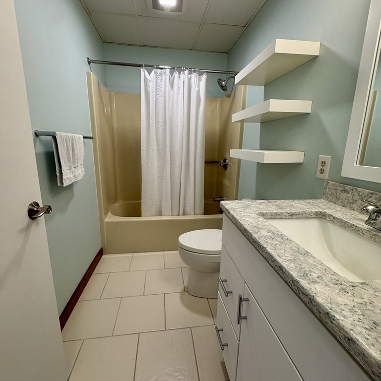 915 Hathaway Road, Unit 105 New Bedford, MA 02740 - Photo 14 of 24 a bathroom with a granite countertop sink a toilet and shower