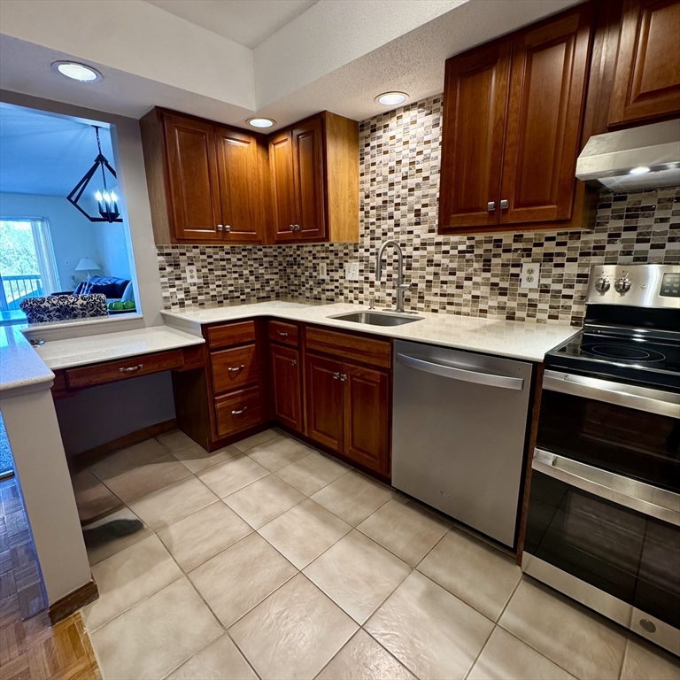 915 Hathaway Road, Unit 105 New Bedford, MA 02740 - Photo 3 of 24 a kitchen with stainless steel appliances granite countertop wooden cabinets a stove top oven a sink and dishwasher