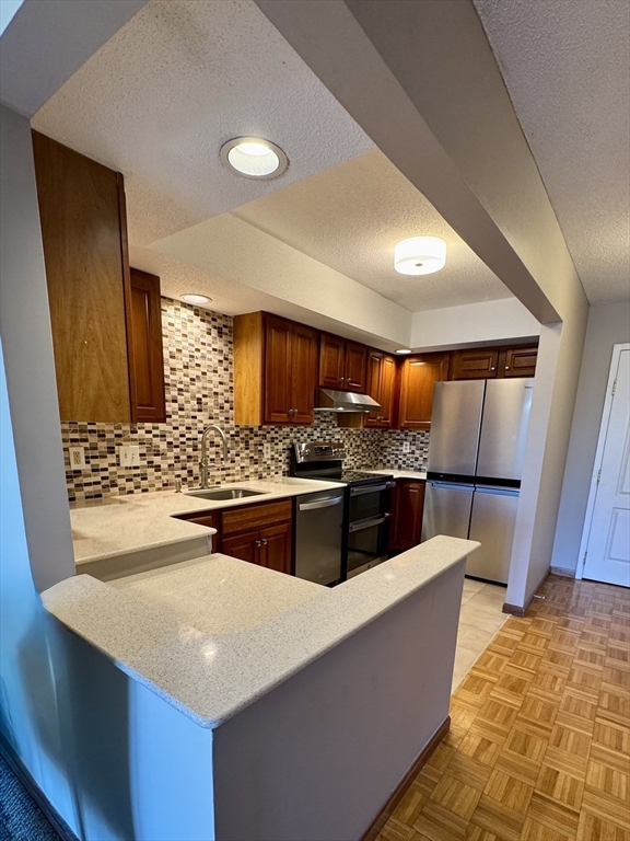 915 Hathaway Road, Unit 105 New Bedford, MA 02740 - Photo 6 of 24 a kitchen with stainless steel appliances a sink and a refrigerator