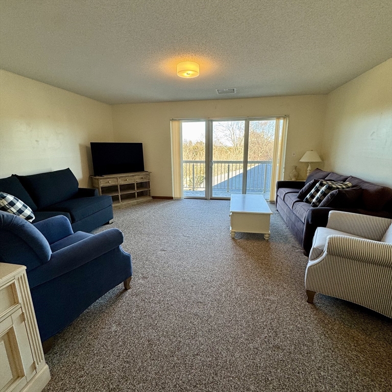 915 Hathaway Road, Unit 105 New Bedford, MA 02740 - Photo 9 of 24 a living room with furniture and a flat screen tv