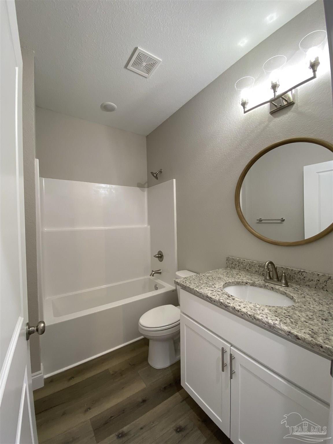 6768 Contentment Street Milton, FL 32583 - Photo 11 of 21 a bathroom with a granite countertop sink a toilet and a mirror
