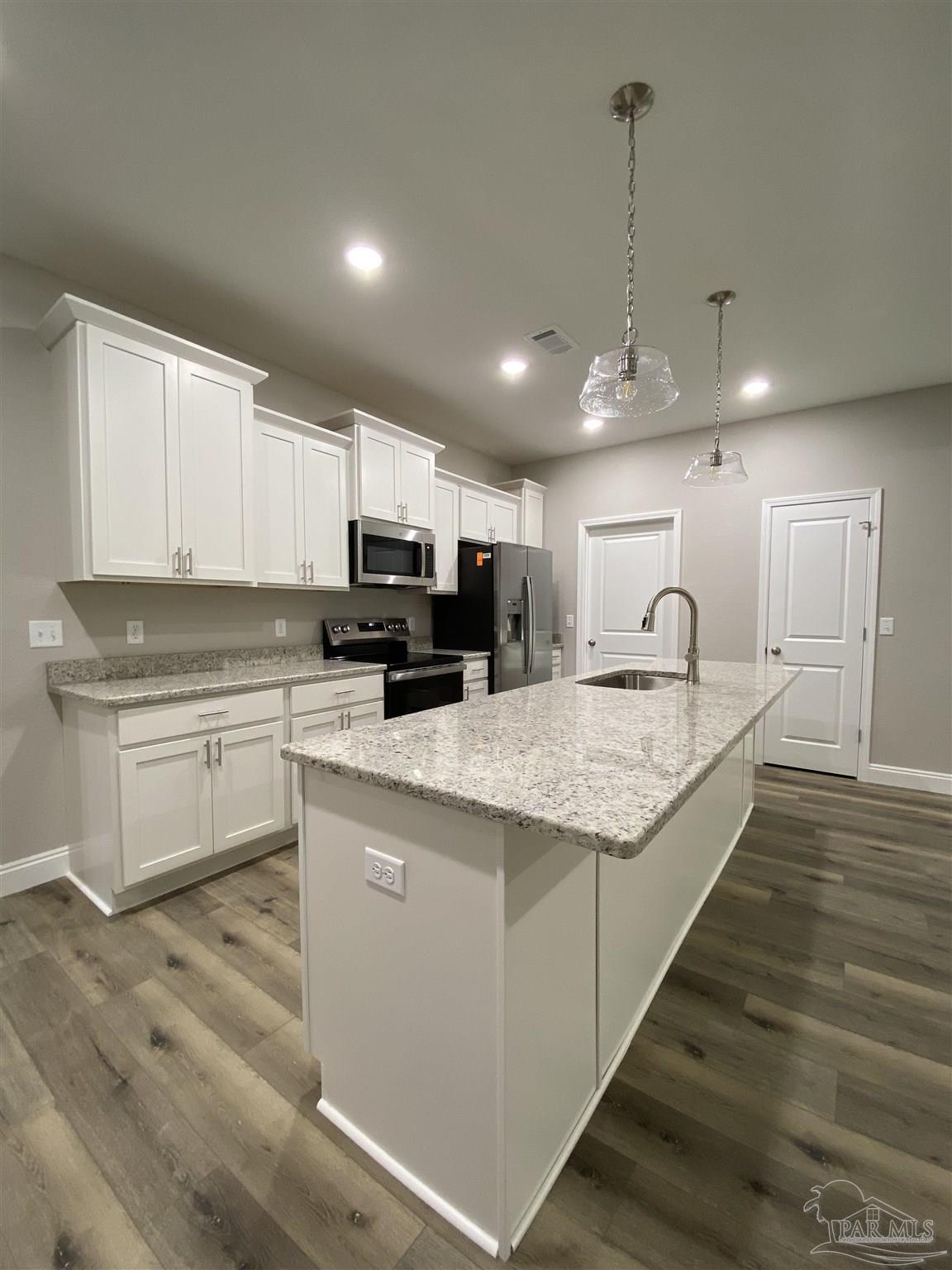 6768 Contentment Street Milton, FL 32583 - Photo 5 of 21 a large kitchen with kitchen island a sink stainless steel appliances and cabinets