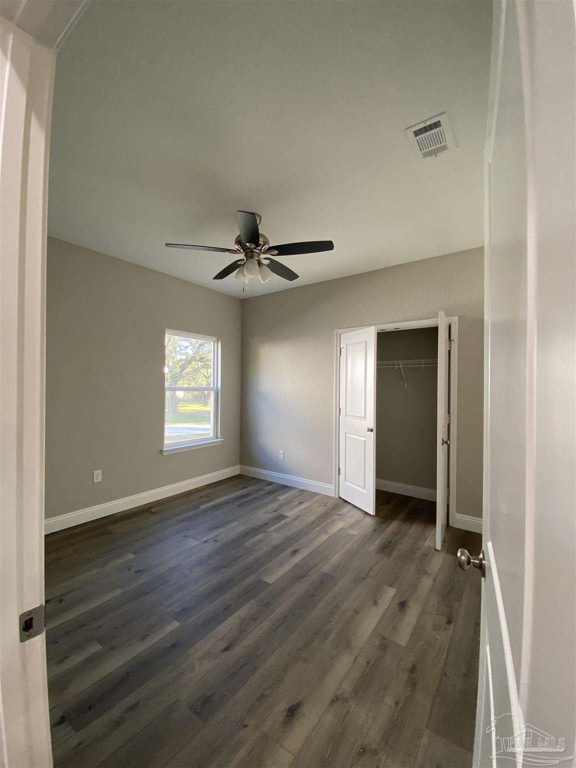 6768 Contentment Street Milton, FL 32583 - Photo 10 of 21 a view of an empty room with window and wooden floor