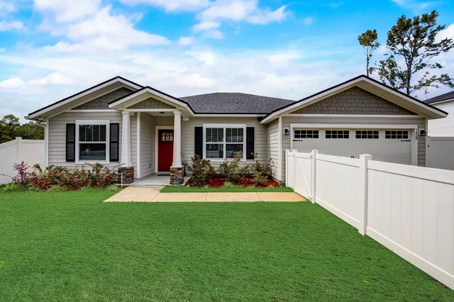a front view of a house with yard and green space