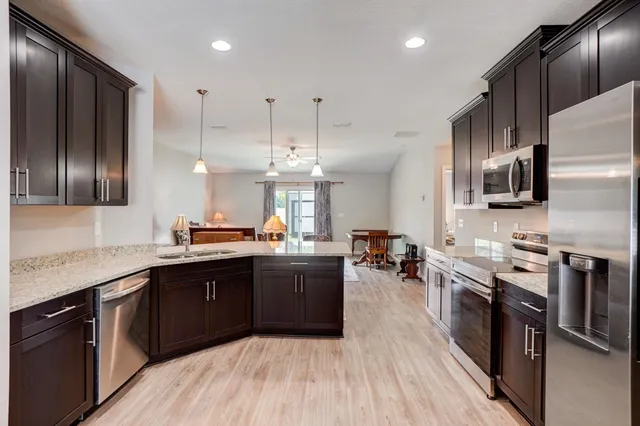 a kitchen with stainless steel appliances granite countertop a sink stove and refrigerator