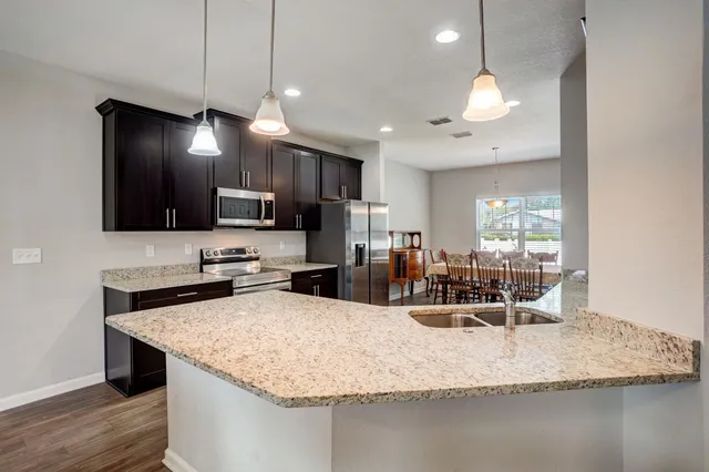 a kitchen with stainless steel appliances granite countertop a sink refrigerator and microwave