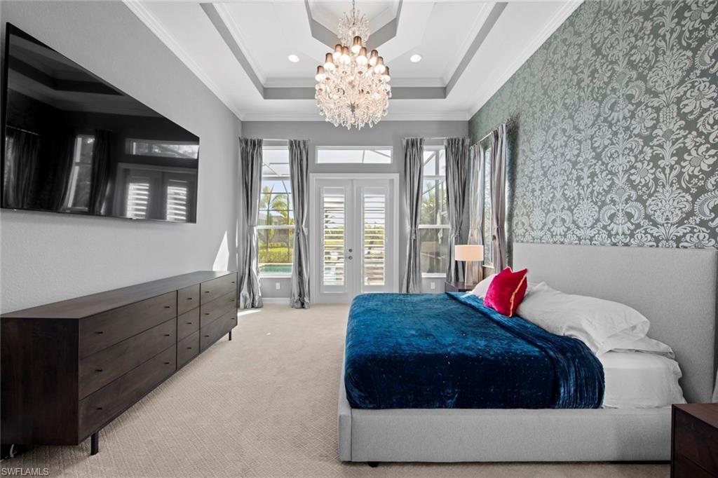 14792 Spinnaker Way Naples, FL 34114 - Photo 18 of 48 a spacious bedroom with a bed and a chandelier
