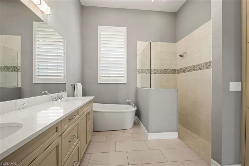 14792 Spinnaker Way Naples, FL 34114 - Photo 20 of 48 a bathroom with a granite countertop sink a toilet and bathtub
