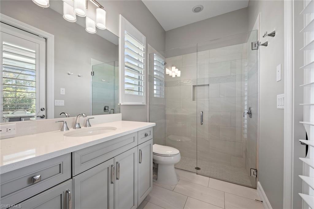 14792 Spinnaker Way Naples, FL 34114 - Photo 23 of 48 a spacious bathroom with a shower sink mirror and toilet