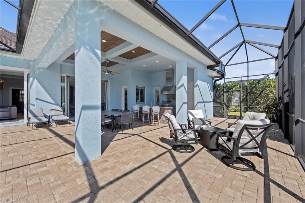 14792 Spinnaker Way Naples, FL 34114 - Photo 35 of 48 a view of a patio with table and chairs and floor to ceiling window
