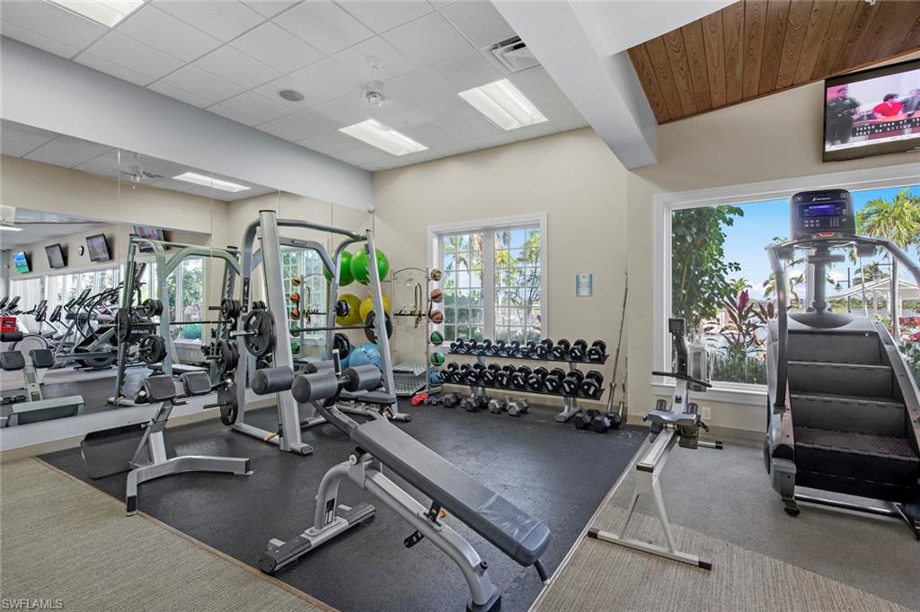 14792 Spinnaker Way Naples, FL 34114 - Photo 42 of 48 a living room with furniture gym equipment and a flat screen tv