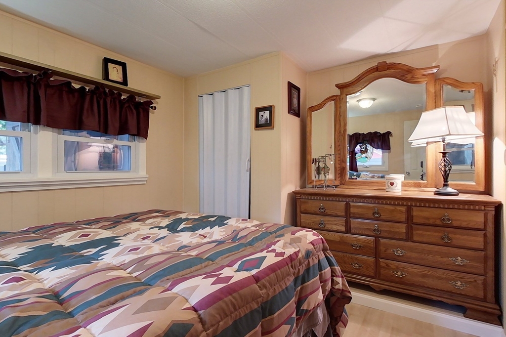 239 Ayer Road, Unit 16 Littleton, MA 01460 - Photo 11 of 22 a bedroom with a bed and a large mirror on the dresser