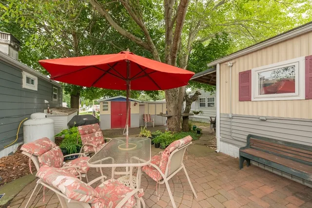 a view of a patio with a table and chairs under an umbrella