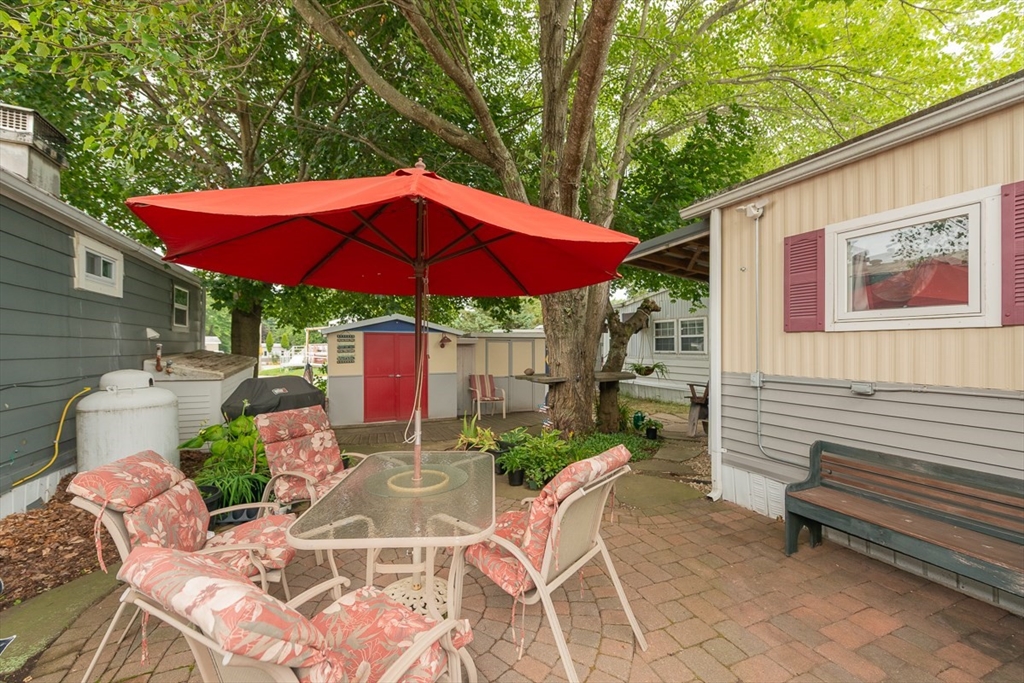 239 Ayer Road, Unit 16 Littleton, MA 01460 - Photo 18 of 22 a view of a patio with a table and chairs under an umbrella