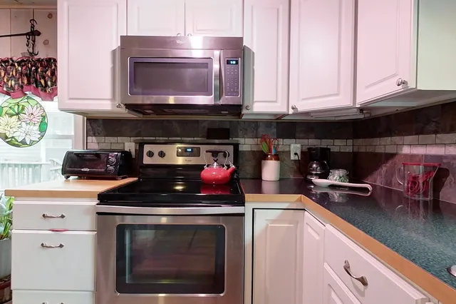 a kitchen with stainless steel appliances granite countertop a stove a microwave and cabinets