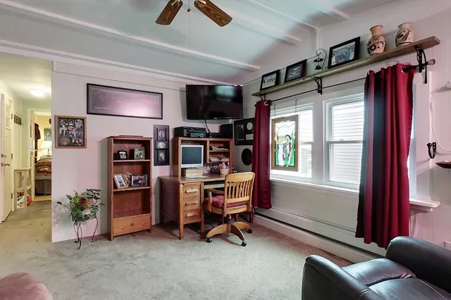 a view of a livingroom with workspace and a window