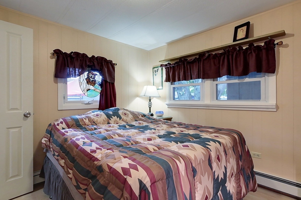 239 Ayer Road, Unit 16 Littleton, MA 01460 - Photo 10 of 22 a bedroom with a bed and a painting on the wall