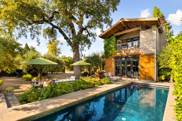 a view of a patio with chairs and a large tree