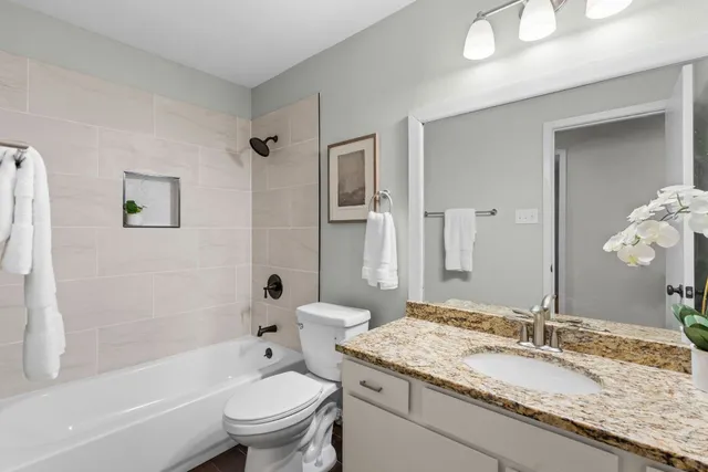 a bathroom with a granite countertop sink toilet and shower