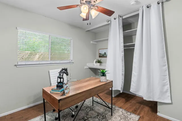 a room with chandelier fan and wooden floor