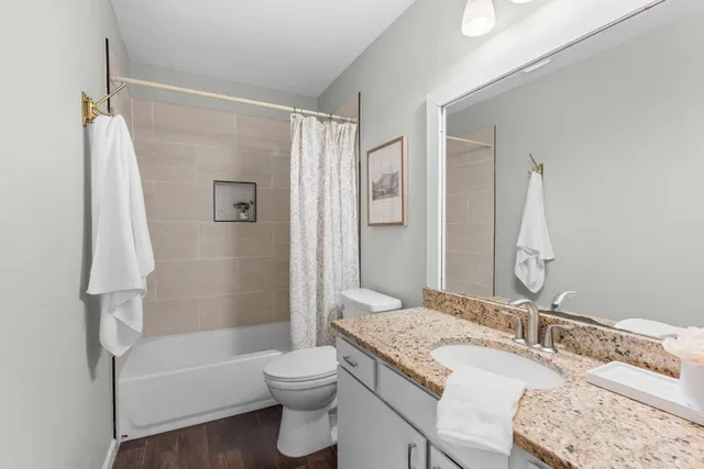 a bathroom with a granite countertop sink toilet and shower