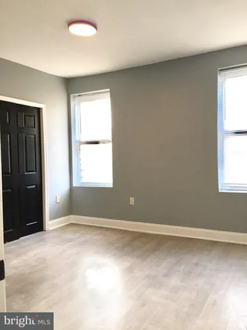 a view of an empty room with closet and a window