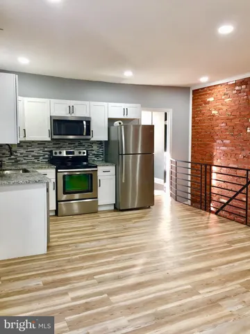 a metallic refrigerator freezer sitting in a kitchen