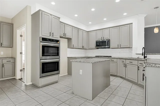 a kitchen with cabinets stainless steel appliances and sink