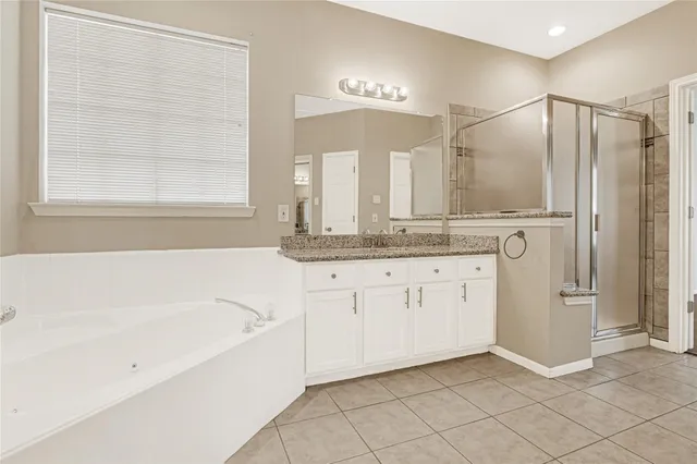 a bathroom with a granite countertop sink mirror and a bathtub