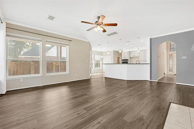 a view of a kitchen with wooden floor and a window