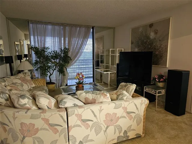 a bedroom with a bed a television and a large window