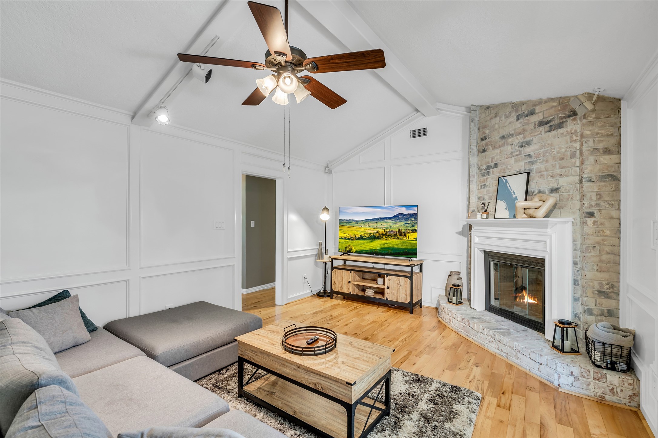 22502 Fields Lane Spring, TX 77389 - Photo 6 of 39 Cozy living room. The space is bright and open, with wood flooring and a stylish entertainment center.