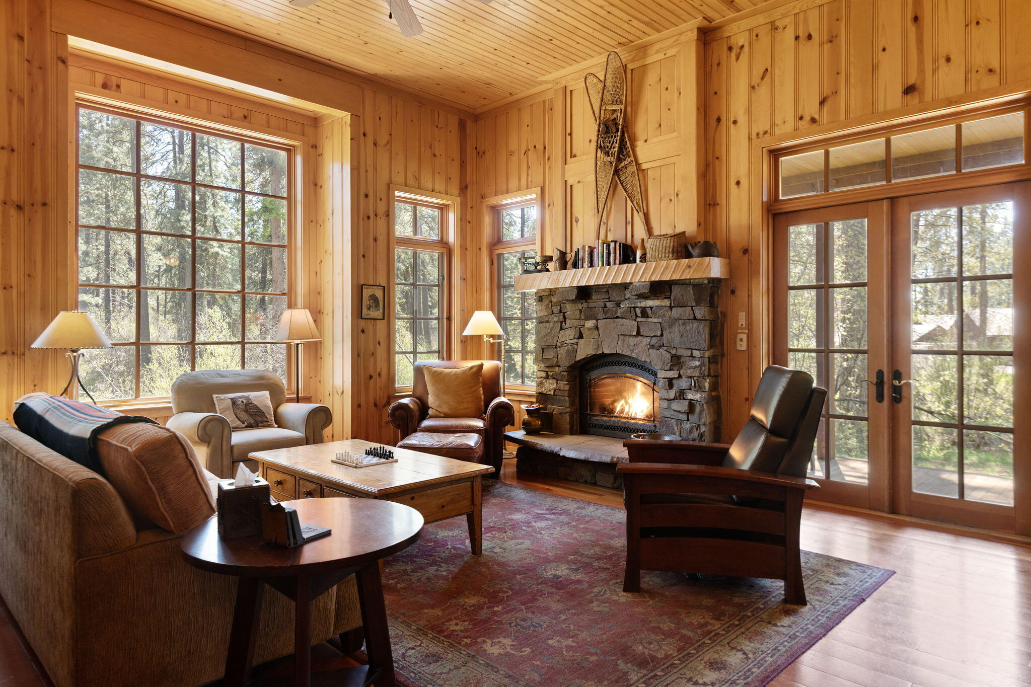 13375 Southwest Forest Service Road, Unit CABIN 18 U1 Camp Sherman, OR 97730 - Photo 4 of 31 a living room with furniture a fireplace and large windows