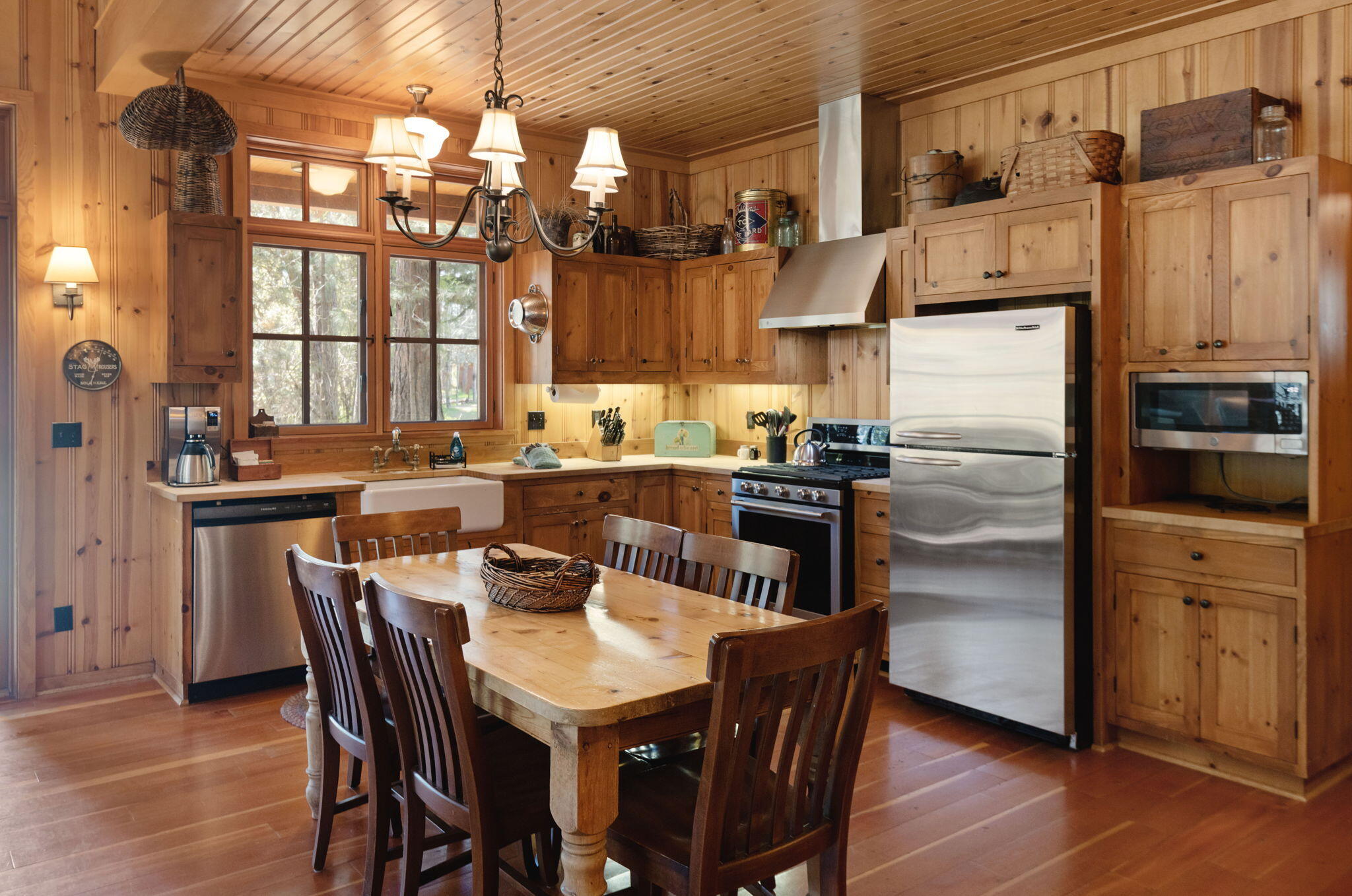 13375 Southwest Forest Service Road, Unit CABIN 18 U1 Camp Sherman, OR 97730 - Photo 5 of 31 a kitchen with stainless steel appliances a dining table chairs refrigerator and sink