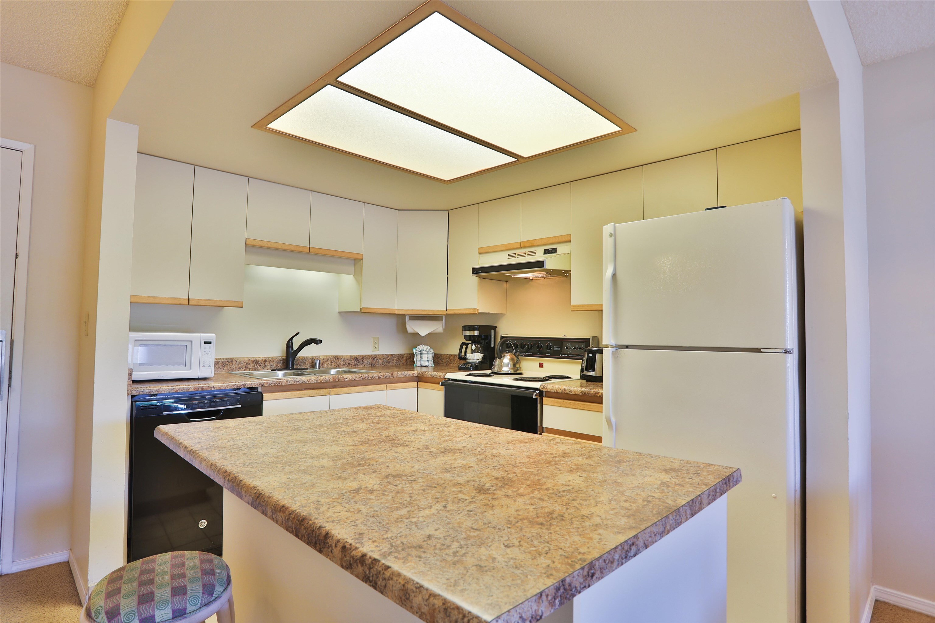 2575 South Kihei Road, Unit G306 Kihei, HI 96753 - Photo 12 of 18 a kitchen with a stove a refrigerator and a sink