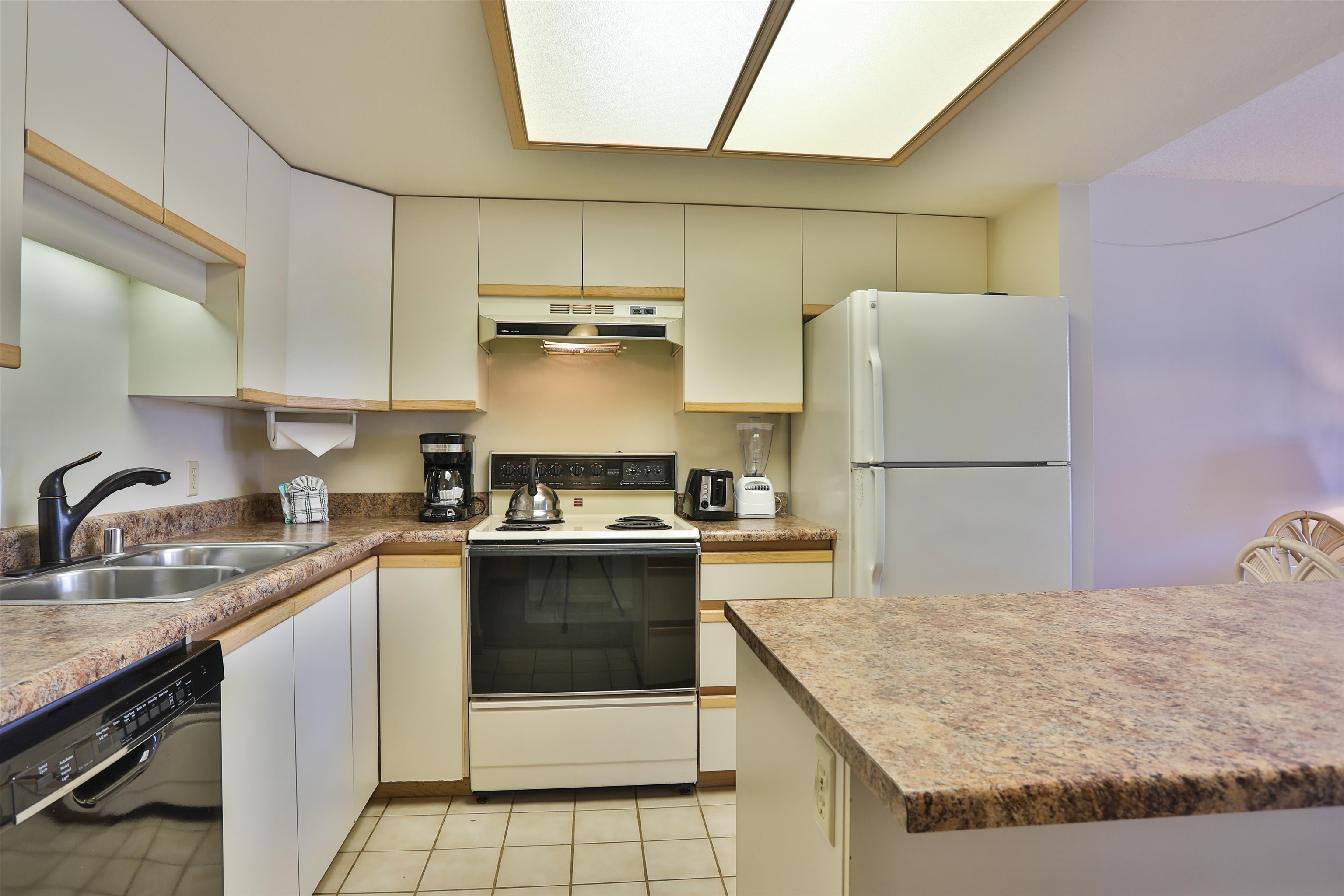 2575 South Kihei Road, Unit G306 Kihei, HI 96753 - Photo 13 of 18 a kitchen with a stove a refrigerator and a sink