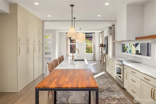 a large kitchen with granite countertop a stove a sink dishwasher and a refrigerator with wooden floor