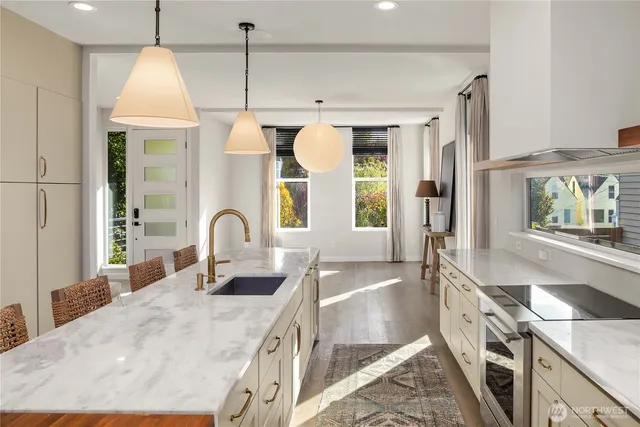 a kitchen with stainless steel appliances granite countertop a sink a stove and a refrigerator