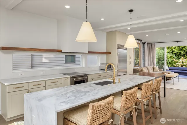 a kitchen with stainless steel appliances granite countertop a sink a stove and a wooden floors