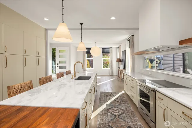 a large kitchen with kitchen island a large counter space a sink appliances and cabinets