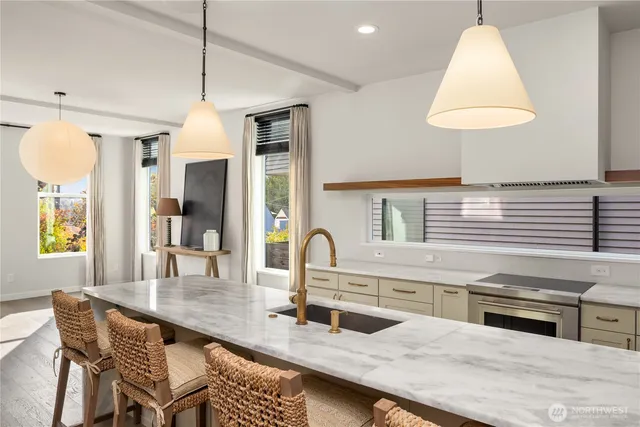 a kitchen with stainless steel appliances granite countertop a sink a stove and a wooden floor